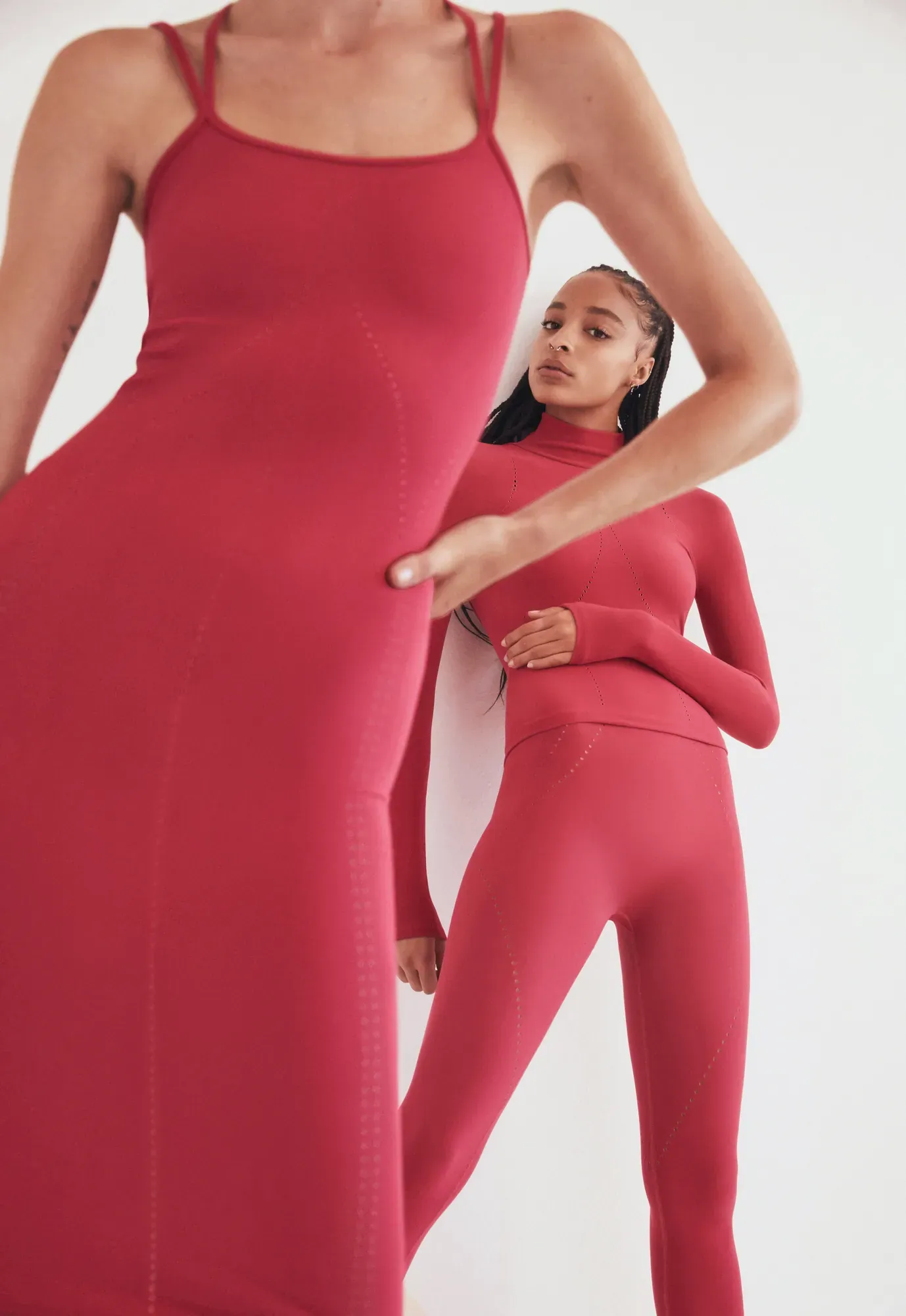 Two models in crimson Dion Lee knit against a white studio wall